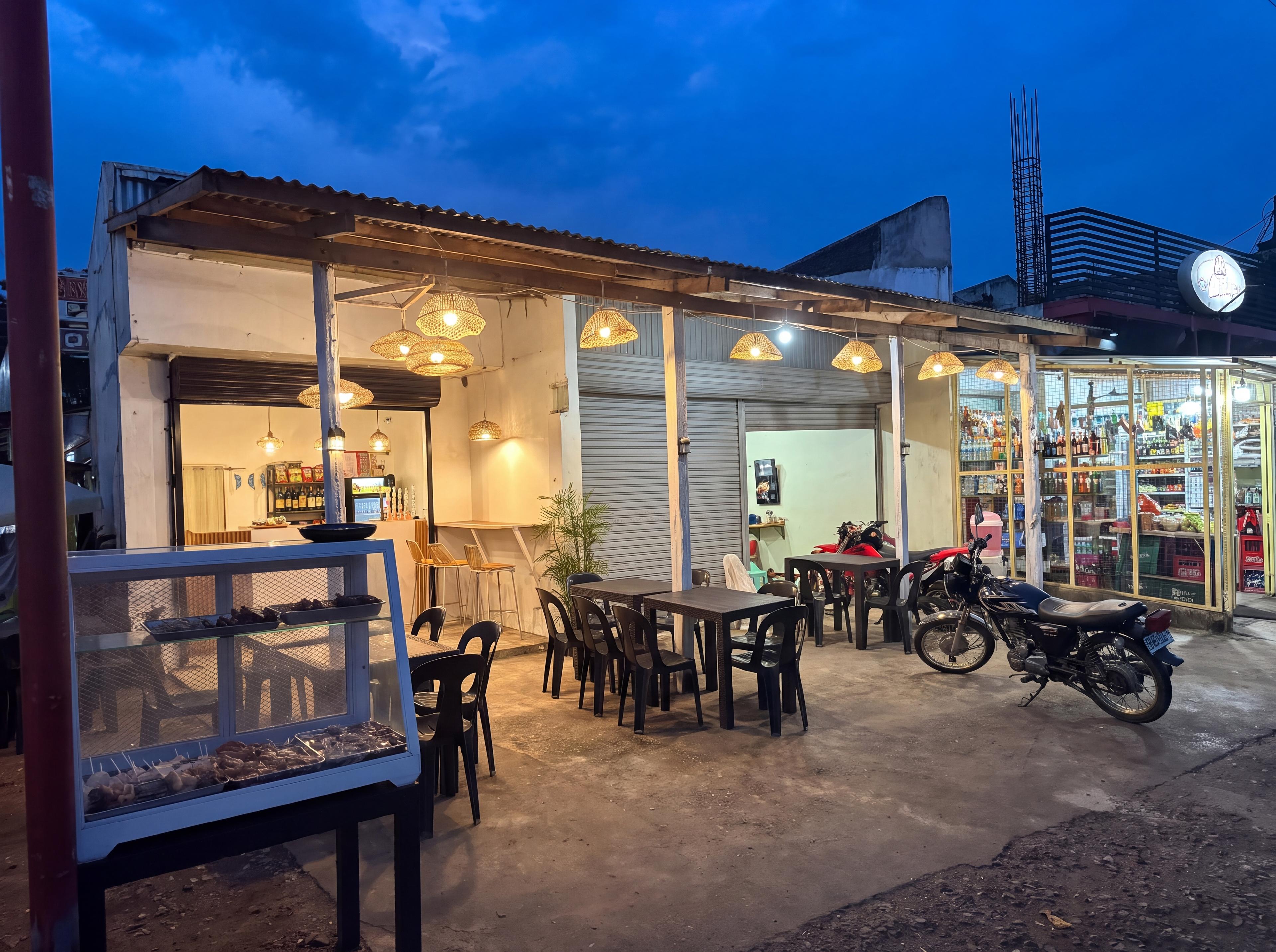 BunTagay restobar storefront at dusk, with warm hanging lights and outdoor seating